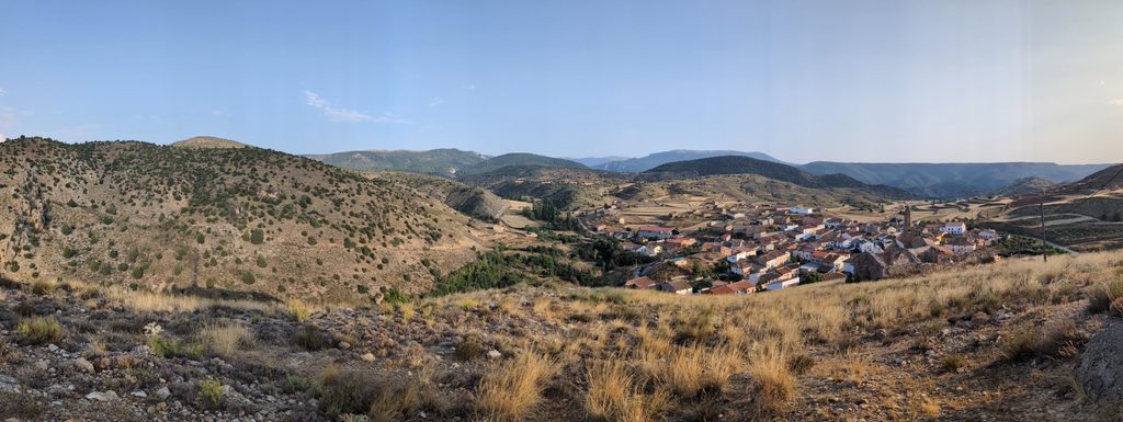 Panorama of a small village of terracotta roofs in a valley among dry, scrub-covered hills