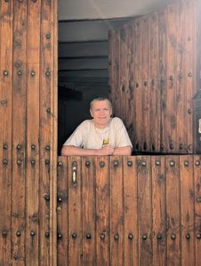 M. Ackerman leaning over a half-open wooden stable door