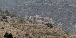 A ruined castle on a scrub-covered ridge
